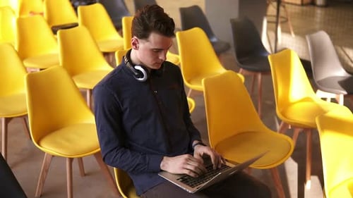 Young Adult Typing on Laptop in Bright Room