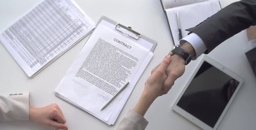 Contract Signing and Handshake at Business Meeting