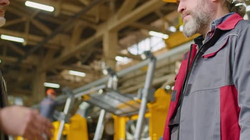 Engineer and Factory Worker Shaking Hands and Talking