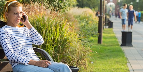Woman Talking on Smartphone in Park on Bench