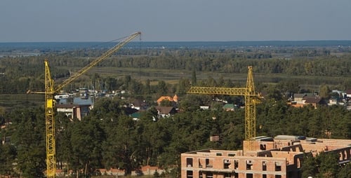 Construction Cranes Overlook Urban Development and Nature