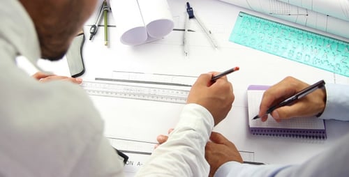 Architects Collaborating on Blueprints in the Office