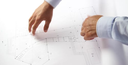 Reviewing Architectural Blueprints in Bright Workplace