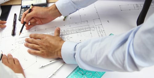 Architects Work on Building Plans in Office