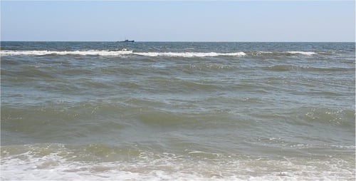Waves Crashing on a Sandy Beach During Daytime