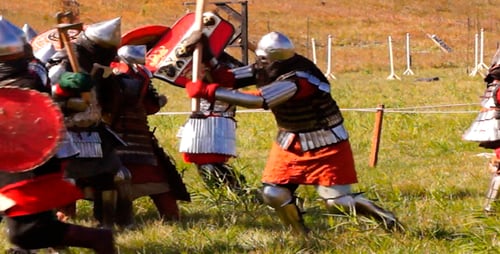 Men in Armor Fight with Weapons in Field