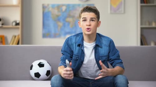 Teenager Watching TV on a Sofa in Living Room