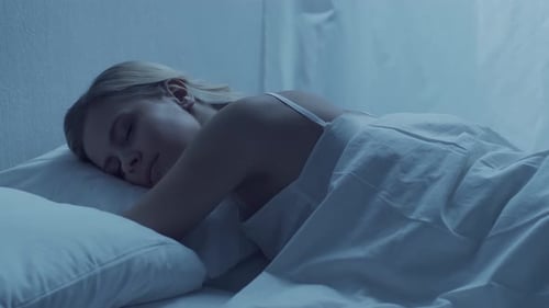 Blonde Woman Sleeping Soundly in Bed at Night
