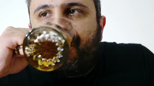Man Drinking Refreshing Beverage from Glass Mug