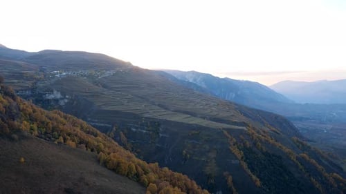 Vallée aux montagnes couvertes de forêts et de champs d'automne