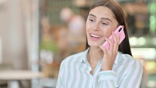 Portrait of Cheerful Young Latin Woman Talking on Smartphone