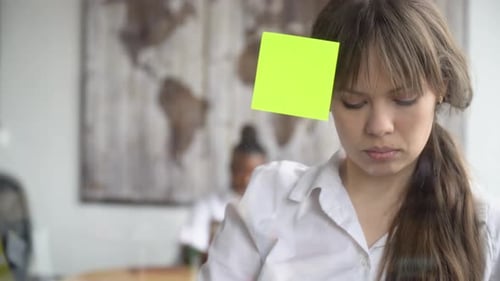 Woman Sticking Sticky Notes to Glass in Office