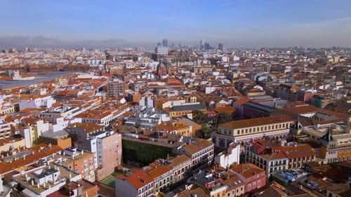 Flying over rooftops toward skyline in Madrid Spain