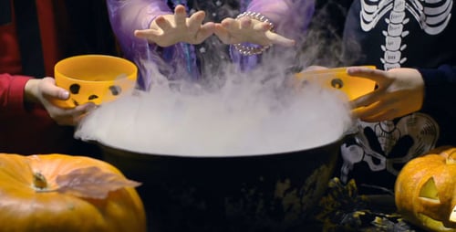 Children Dressed in Halloween Costumes Around Cauldron