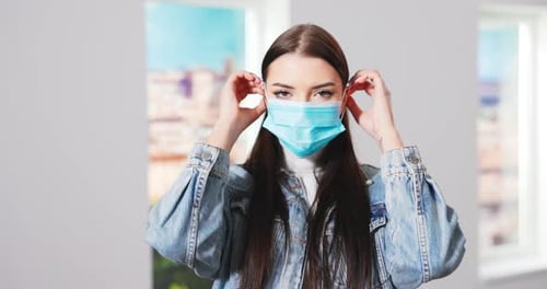 Woman Puts on Surgical Mask for Protection