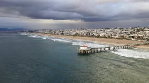 Drone sunset view of Manhattan Beach, California. Cloudy skies. Panning