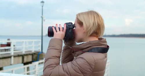 Creative Young Female Photographer Takes Pictures with a Professional Camera
