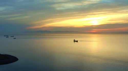 Bulk Carrier Ship at Anchor in Orange Sunset Aerial View