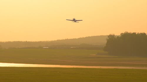 Small Airplane Taking Off at Sunrise in Rural Area