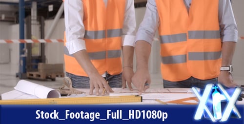 Engineers Working on Blueprints in Warehouse Setting