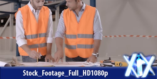Construction Workers Reviewing Blueprints at Construction Site
