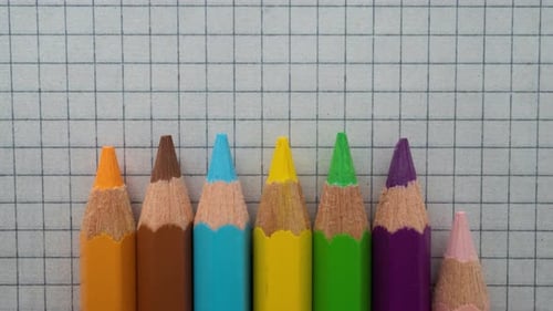 Colored Pencils Appear on Graph Paper Background