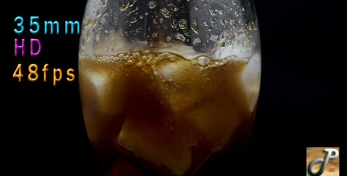 Dark Beverage Pouring Over Ice in Glass