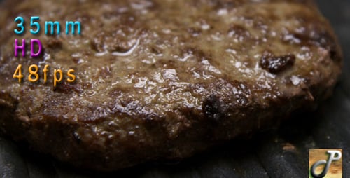 Juicy Hamburger Patty Sizzling on a Grill