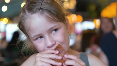 Child Girl Eating Tasty Burger in Restaurant