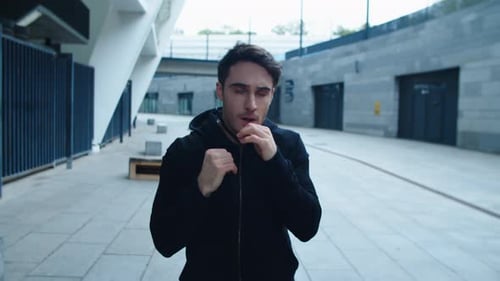 Man Practices Shadow Boxing in an Urban Setting