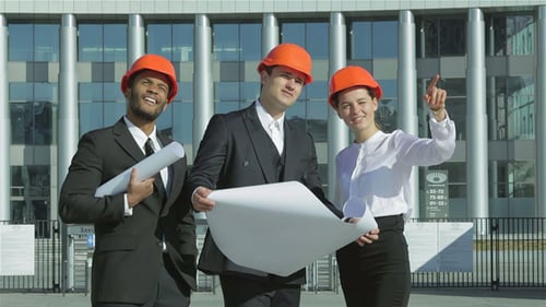 Young Engineers Reviewing Plans at Construction Site