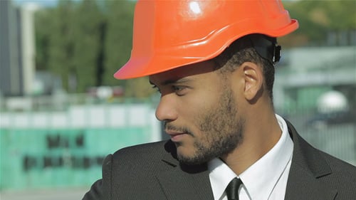 Engineers Reviewing Blueprints at Construction Site