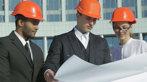 Architects Discussing Blueprint near Modern Office Building