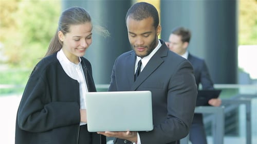 Businesspeople Shake Hands and Collaborate Outdoors