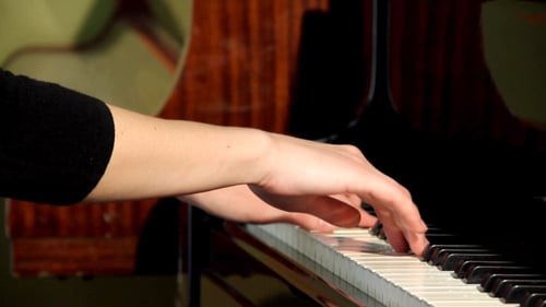 Woman Playing Piano Keys in a Home