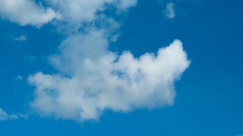 Billowing Clouds Drifting in Blue Sky on Sunny Day