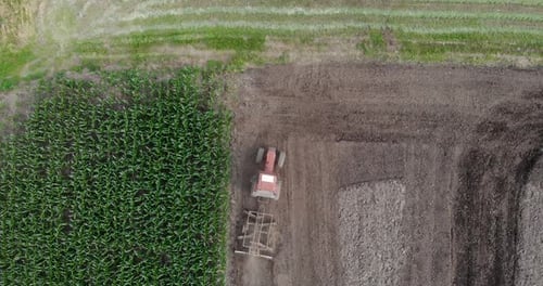 Top View Of A Tractor Tilling The Soil At The Farm Field. aerial drone