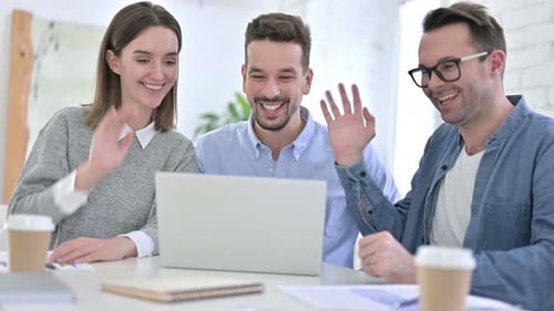 Three Young Adults Waving on a Video Call