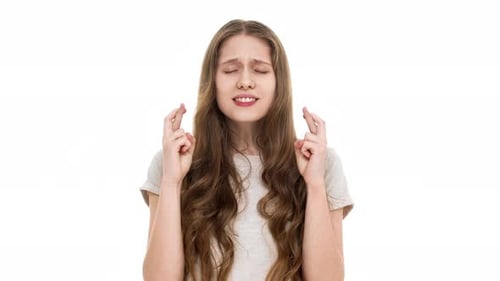 Young Woman Crossing Fingers, Hoping for Good Luck