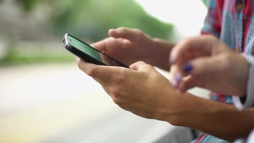 Hands Using Mobile Device in Urban Setting