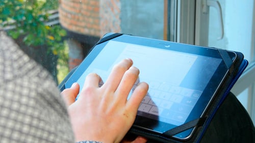 Person Using an Older Tablet Device Indoors
