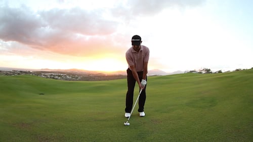 Man Plays Golf on Green Course at Sunset