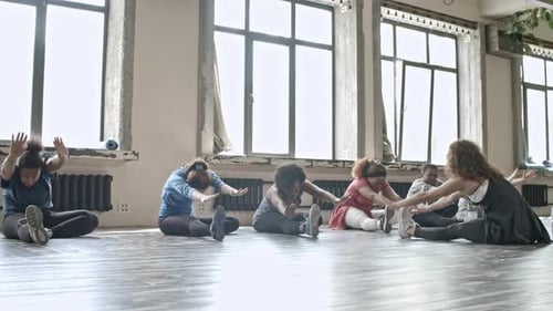 Women Stretching Legs in Flexibility Class