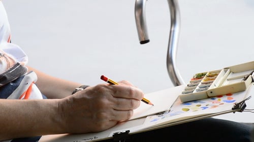 Sketcher Drawing in a Book