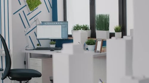 Nahaufnahme des Schreibtisches im Architekturbüro mit Plänen für digitale Blaupausen auf dem Computer