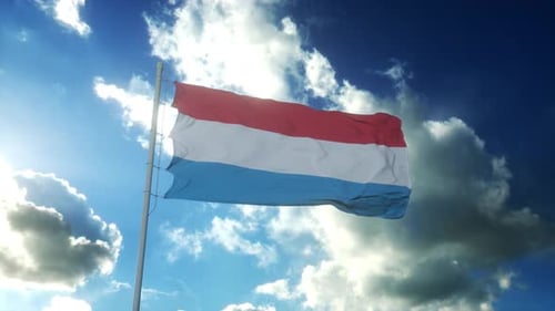 Flagge Luxemburgs weht im Wind vor wunderschönem blauem Himmel