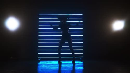 Woman Dancing Silhouetted Against Blue Neon Lights