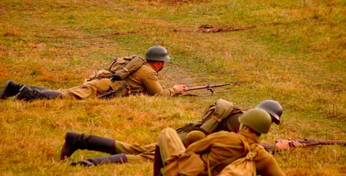 Soldiers Lying Prone, Firing Rifles in Field