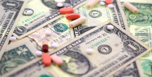 Pills and Capsules Scattered on United States Currency