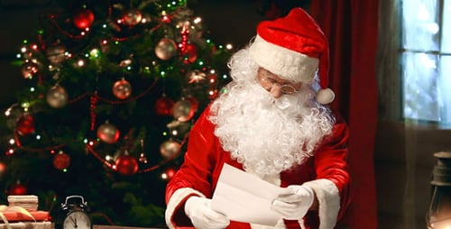 Santa Claus Reading Christmas Letter at Wooden Desk